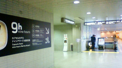 ナインアワーズ成田空港への案内表示とエスカレーター